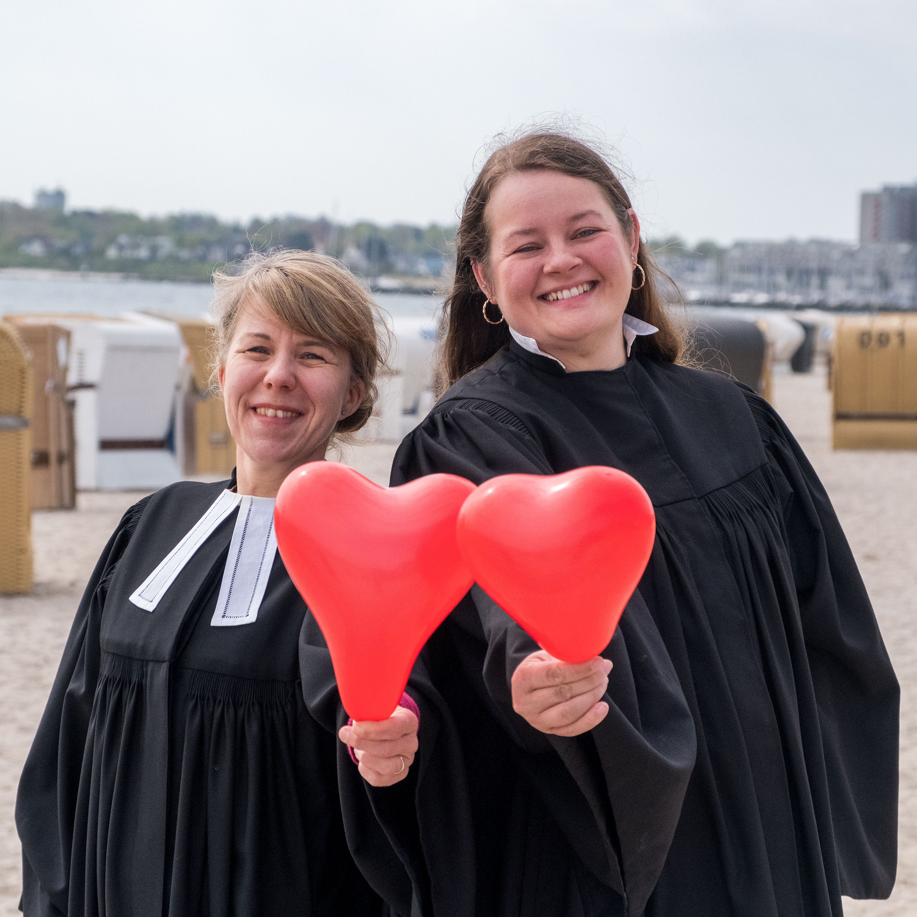 Pastorin Lena-Katharina Schedukat und Pastorin Janika Frunder mit Herzballons am Strand
