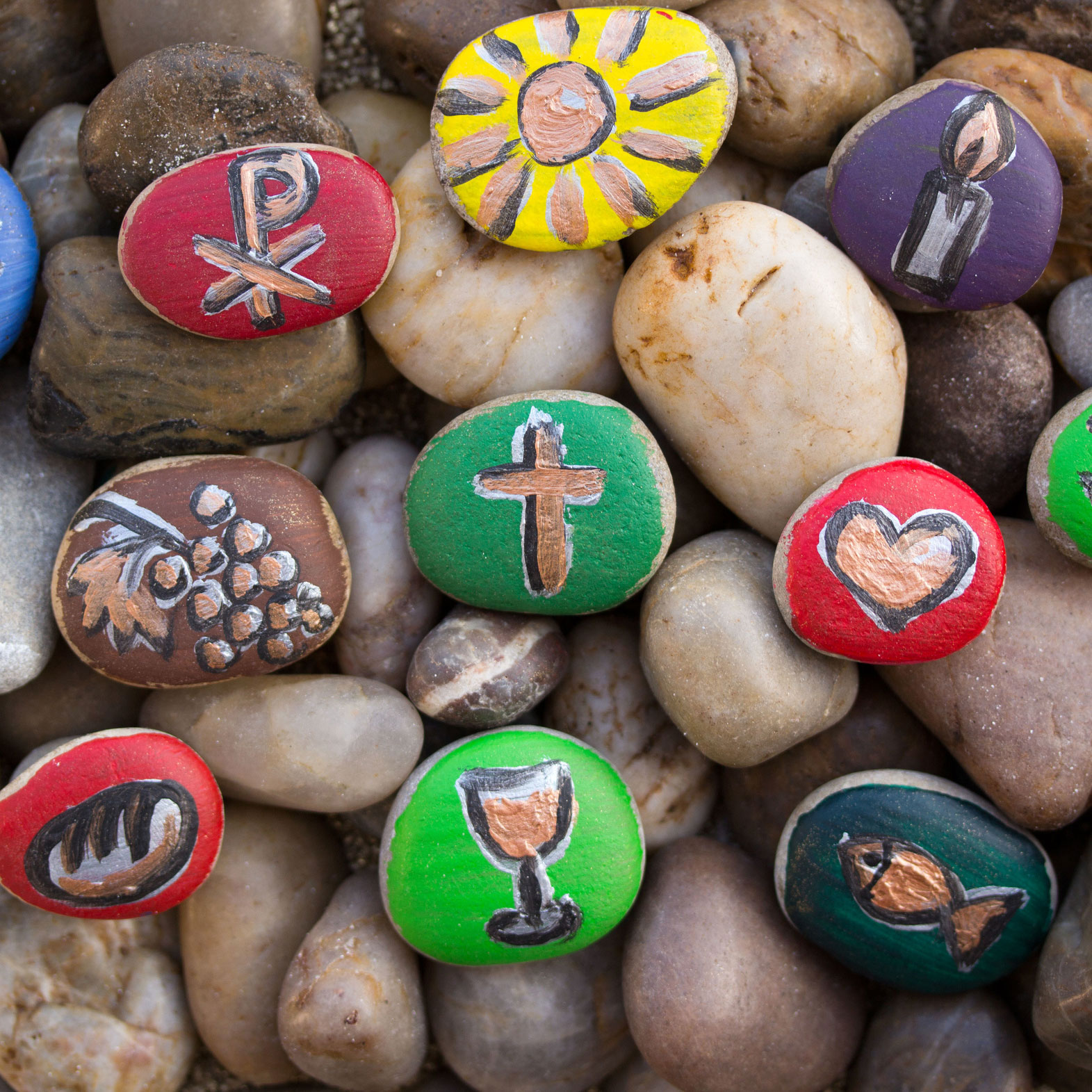 Steine, bunt bemalt mit Gottesdienstsymbolen